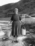 Girl carrying pails with yoke at Vestvaago [Lofoten Isles, Norway]
