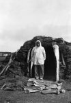 Eskimo house and its owner, Point Hope, Bering Strait, Alaska (note unusual decoration of whale-ribs round doorway)